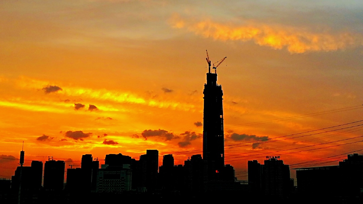 [晚霞中的"绿地中心"]由于城市航空净空管理,原设计高度为