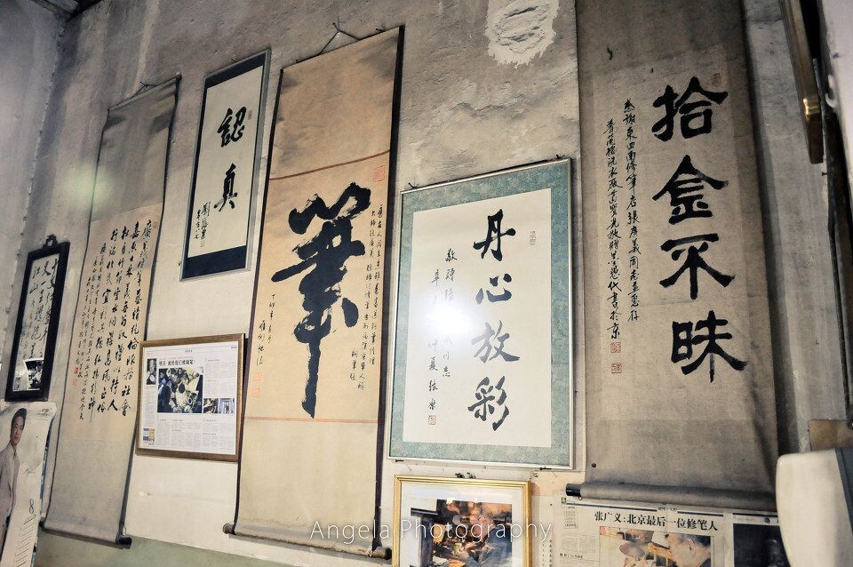 04<br />
墙上的表彰字画除了关于修笔技术好的,还有很大一部分是关于拾金不昧、诚信、认真的。小店并没有座椅,我指着一个挨着柜台的那种过去老北京石墩儿问可不可以坐这儿,张老说“坐吧坐吧,不过这石墩儿挺凉的,你注意着点儿。”这时我才注意到这店里连电扇都没放,可是这屋却异常凉快,但真的不是那种阴森森的凉。房顶很高,墙也没有刻意粉刷,就是典型的老北京平房的样子。