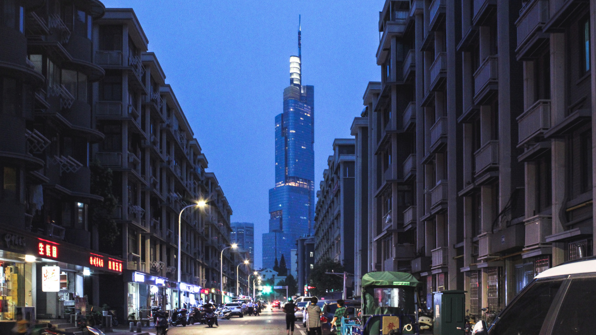 南京西桥颐和路旁,旧建筑和街道和远处紫峰大厦形成鲜明对比