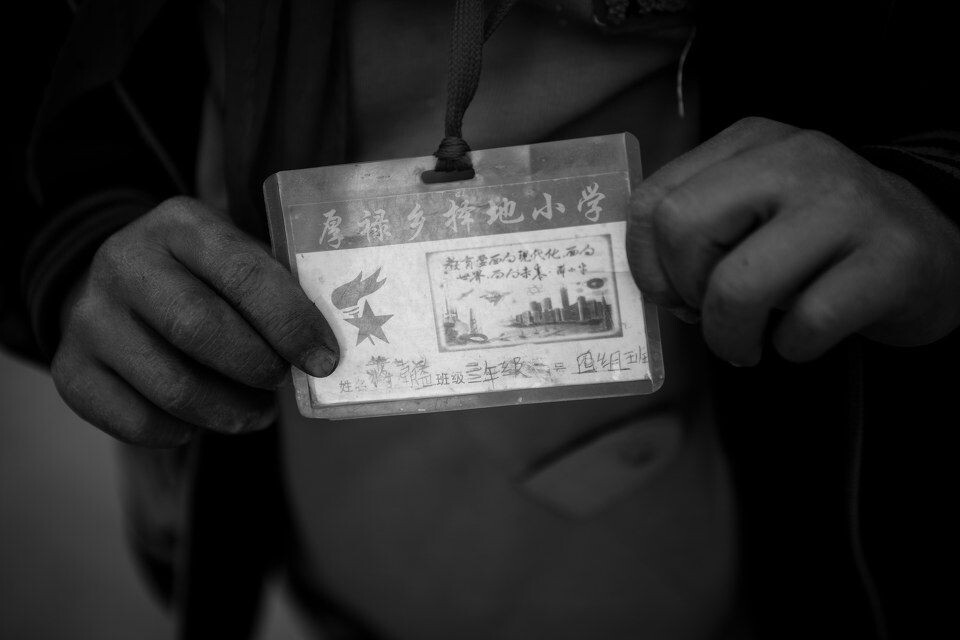村事<br />
学校发的学生证。绝大多数孩子最远到过的地方不过是离这一小时车程的桂平市区,一个小小的地级市而已。他们也许很难想象学生证上的高楼大厦到底长的什么样,更没办法想象得出住在或工作在这样的高楼里会是怎样的一种感觉。