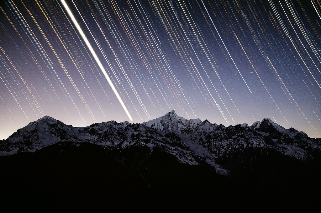 晴朗无月的梅里夜空，冬季银河清晰可见，金星（图中最亮的轨迹）和黄道光使得卡瓦格博南侧的山脊轮廓即使在黑夜中也十分明显。<br />
实际上这是我第一次拍星轨，地景是昏影结束之前拍摄的，由于没有月光补充使得画质很差，细节追加也只能尽力而为了