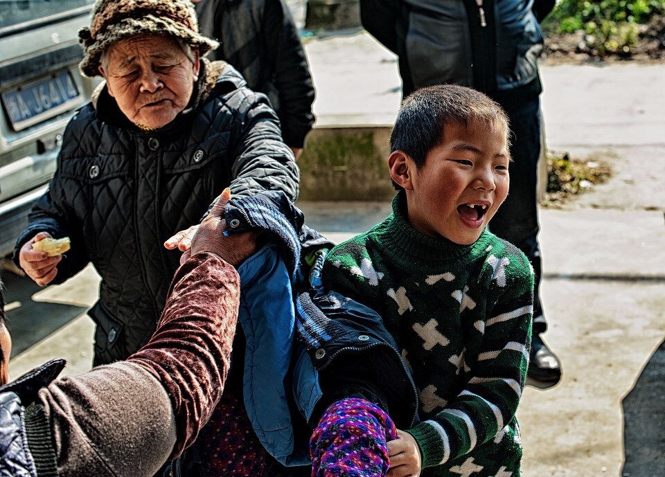 小孩子迫不及待地脱去衣服跑出去玩