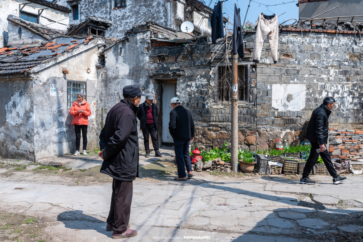 邻居们在巷子口聊天,晒太阳.