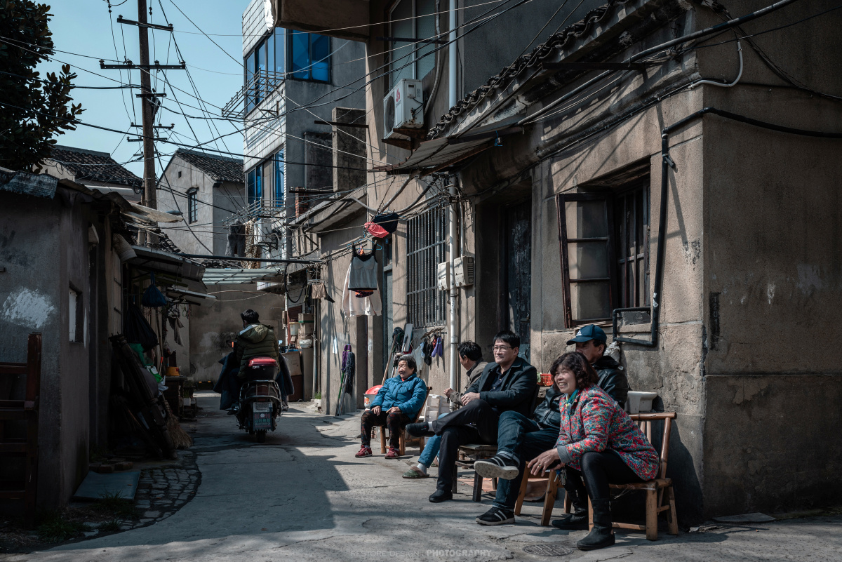 邻居们在家门口晒晒太阳,聊聊家常.