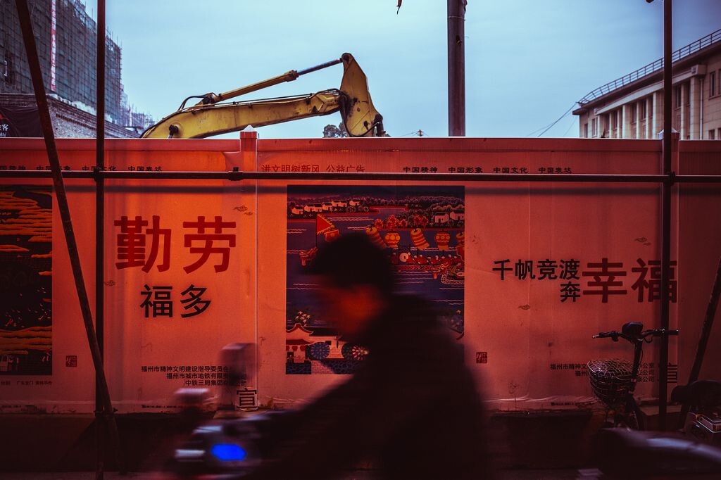 修建地铁的围墙上“幸福”、“勤劳”的大字,赫然醒目。低头而过的行人,匆匆忙忙,似乎无心也无法顾及眼前的一切对他来说是否幸福。