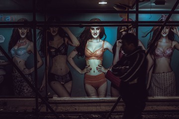 昔日光鲜亮丽的摩登女郎海报，如今已沦为凌乱建筑里的一个寻常角落，借着微落的灯光，与周遭的一切形成了鲜明的反差