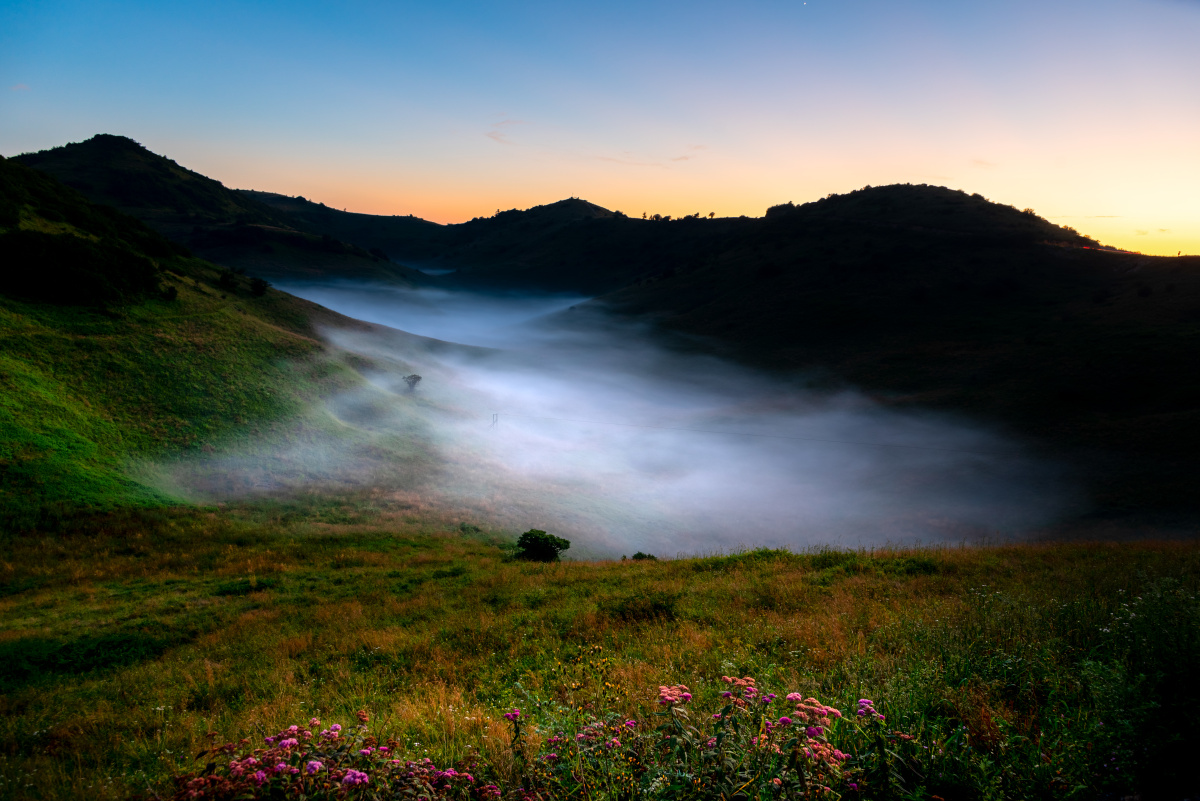 安康岚皋神田草原日落时分草原上水洼里雾气弥漫
