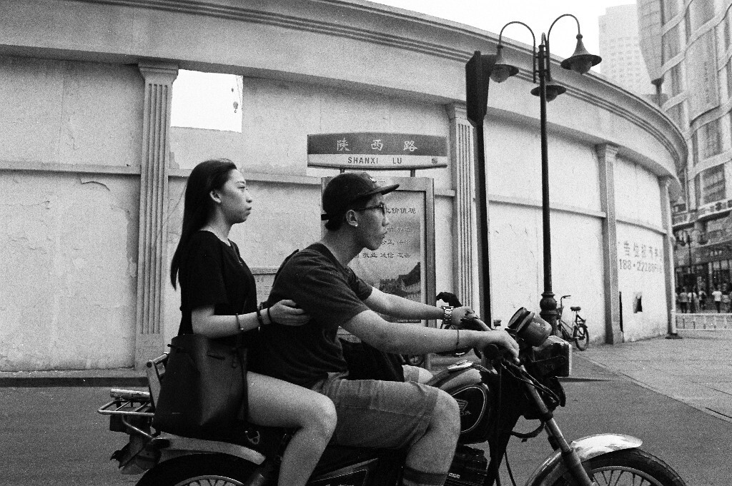 陕西路和滨江道交口，一个青年男子带着他的女朋友骑摩托路过，等洗出来的时候发现，两人还都是复古文艺青年。
