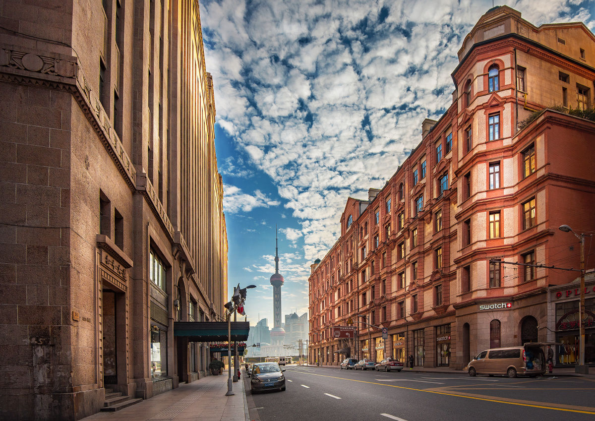 历史与现代的交汇处,晨光中玻璃窗被映得一半天蓝一半金黄