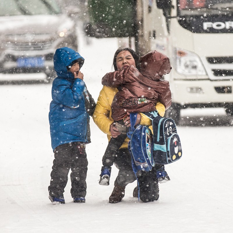 这是东北沈阳的第一场大雪，在雪中抓拍到一个母亲，带着她的孩子艰难的走在上学路上。