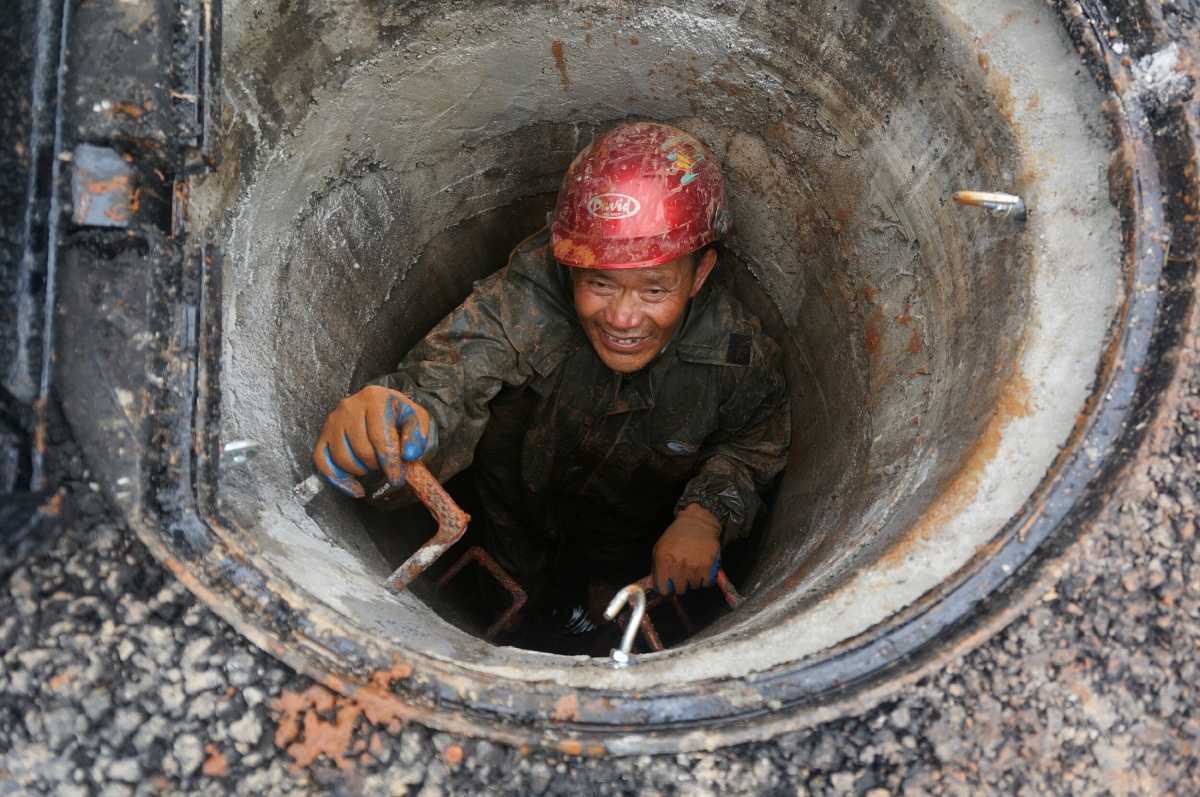 清理堵塞污水管道的清淤工人他们是地下清道夫