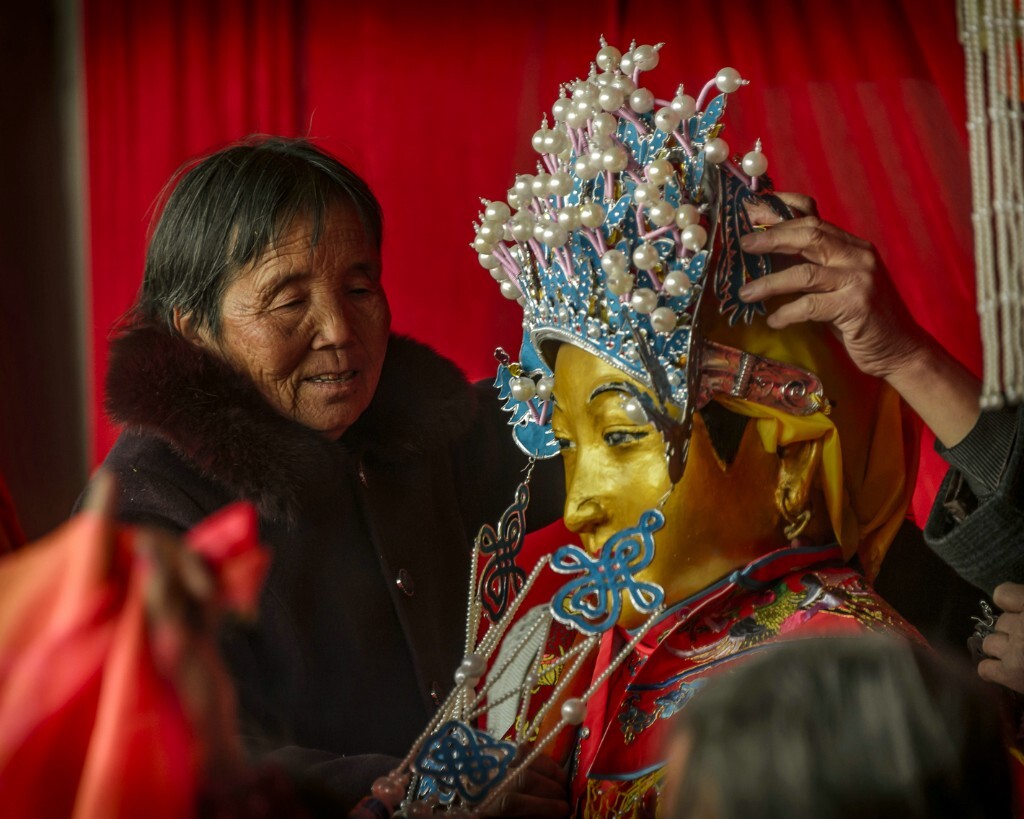 德高望重的村妇为城隍娘娘更衣换装。