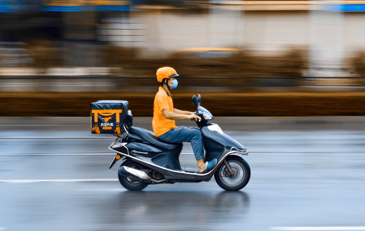 送餐员,下着小雨,走在马路上,看见一名送餐小哥就拍下了这一幕.