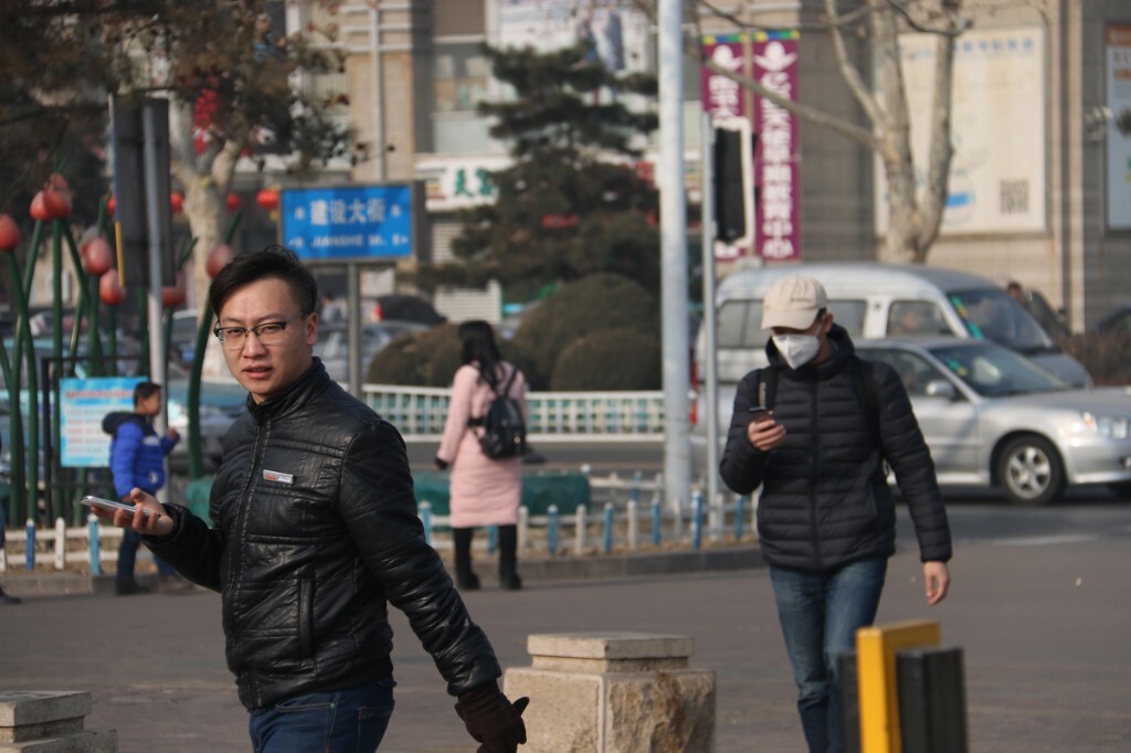 20160102,秦皇岛,空气质量指数:225,重度污染。但在人民广场遇见的带小孩子来玩的人绝少有戴口罩的。 在刚要离开的时候,遇见两位帅哥先后走过来。前面的一位没带防霾口罩,他后边的那位却防护的比较好,走过去上前询问,果然不是本市的人,他告诉我是北京过来的。在帝都严重雾霾的熏陶下,他已习惯了做好防护。原创,拒绝后期制作。