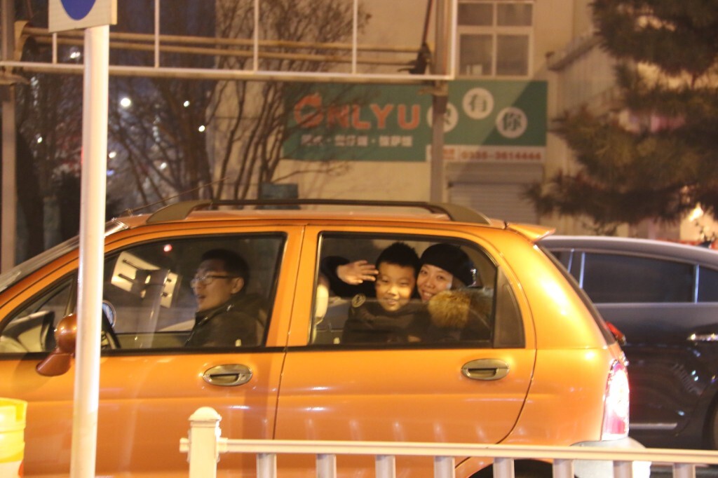 20151230,秦皇岛,空气质量指数109,空气质量轻度污染。经过了连日的重度雾霾,在新年到来之前,终于天气情况有了很大的好转,夜晚,在路口等红灯的汽车里,一对母子发现了我在离他们大约20米的人行道上拿相机对着她们拍照,我对她们笑着招手又指指我的相机,那位母亲摇下车窗,和儿子一起笑着和我招手,虽然隔着很远的距离,我们彼此陌生的人却因为一个微笑、一个友好的手势,而不禁心生欢喜。没有严重雾霾的日子,我们可以摇下车窗,我们可以和遇到的人微笑致意。原创,拒绝后期制作。