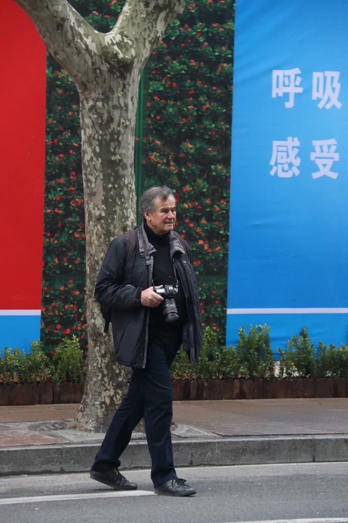 他走来走去，寻找拍摄时机。