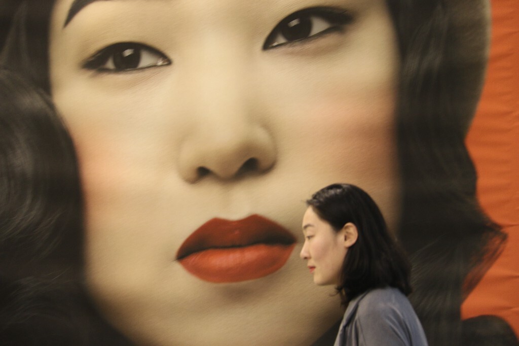 2016艺术北京博览会上，景德镇瓷器工作坊的韩女士走过展厅墙上一位韩国女摄影师的自拍照，东方之美竟是如此吻合。（原创，拒绝后期制作）