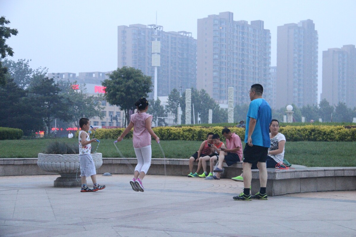 实时空气质量指数185,中度污染。没有任何防护,姐弟俩在爸爸的知道下练习跳绳。