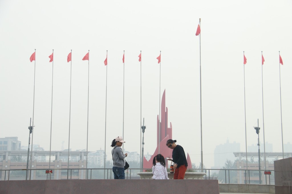 20161002，秦皇岛，空气质量指数150，轻度污染，中午时分，到人民广场游玩的祖孙三代人，尽管空气质量临界到中度污染了，但从小朋友到外婆都没有任何防护措施。原创，拒绝后期制作。