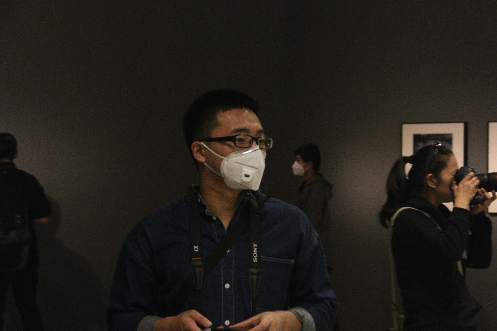 2016101615:00，北京，空气质量指数131，轻度污染，在中央美术学院美术馆内，《观之物语》摄影展现场，观众戴着防霾口罩。