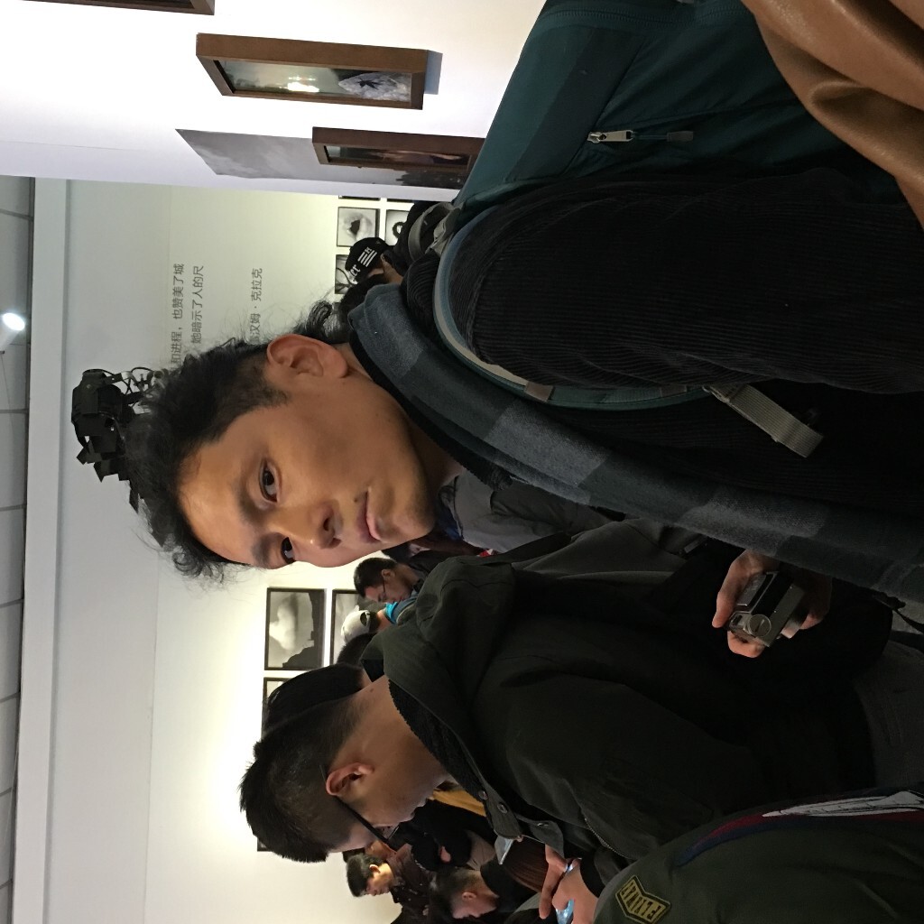 这张就是我拿手机对着他拍时抓拍到的他看我的眼神，其实后来和他聊天时他挺和蔼，也很爱笑。