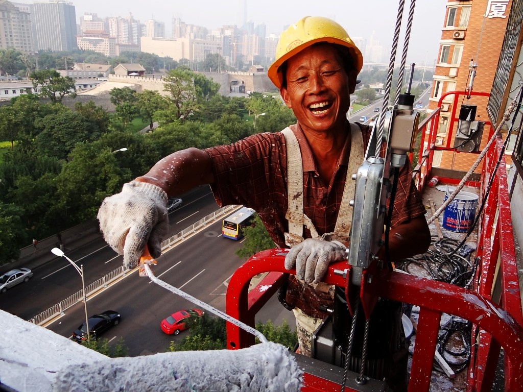 21拍摄于北京崇文门东大街,一位工人正在粉刷楼房外墙,虽然工作危险又