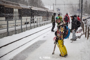 在大雪中等火车的滑雪少年