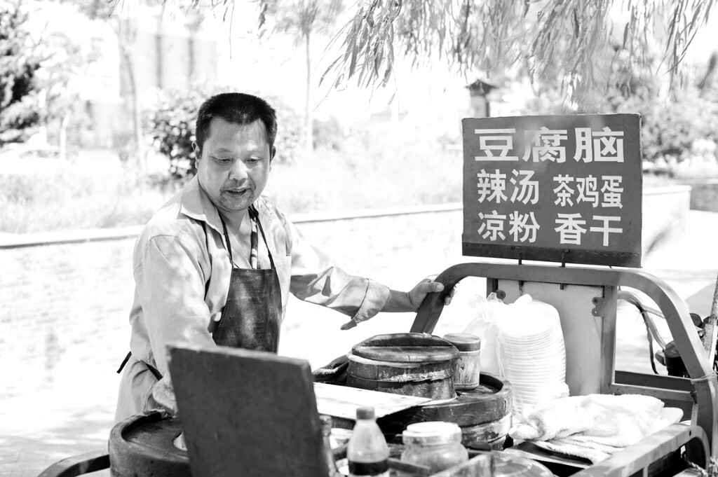 古镇出口处的流动小吃摊,老板今年59岁,早年挑担卖豆腐脑,现在改用三轮车。小吃物美价廉,生意颇不错。