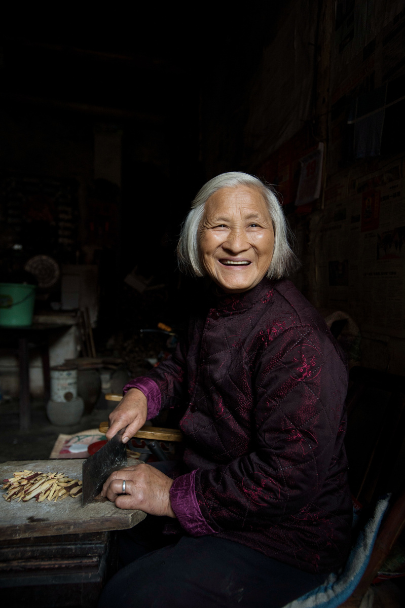  br /> 68岁的潘家奶奶在切红薯喂兔子. br /> 我说,给你拍张照吧.