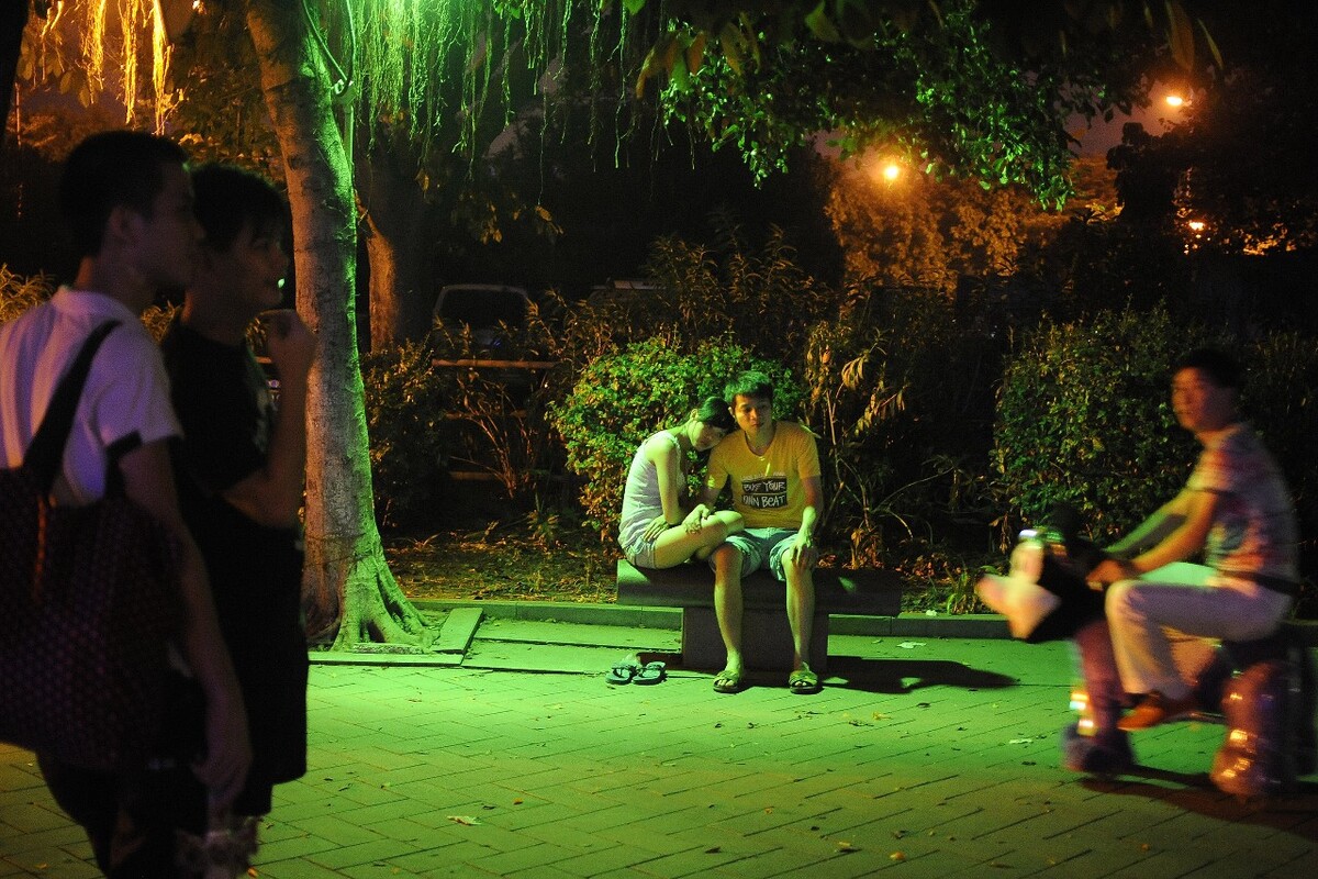 2012年8月4日,广州市员村江边广场,坐在石凳上的青年男女。