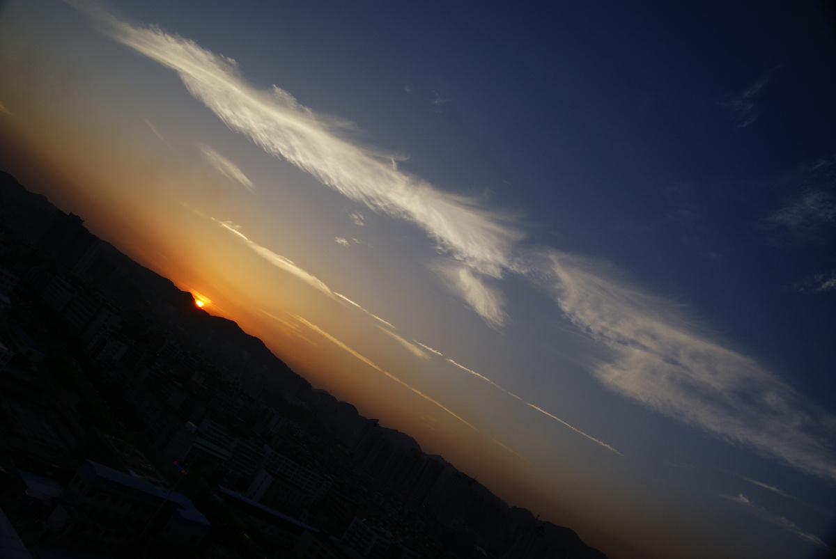 太阳即将没入地平线,余晖染红天际,让丝丝云霞显得清淡.