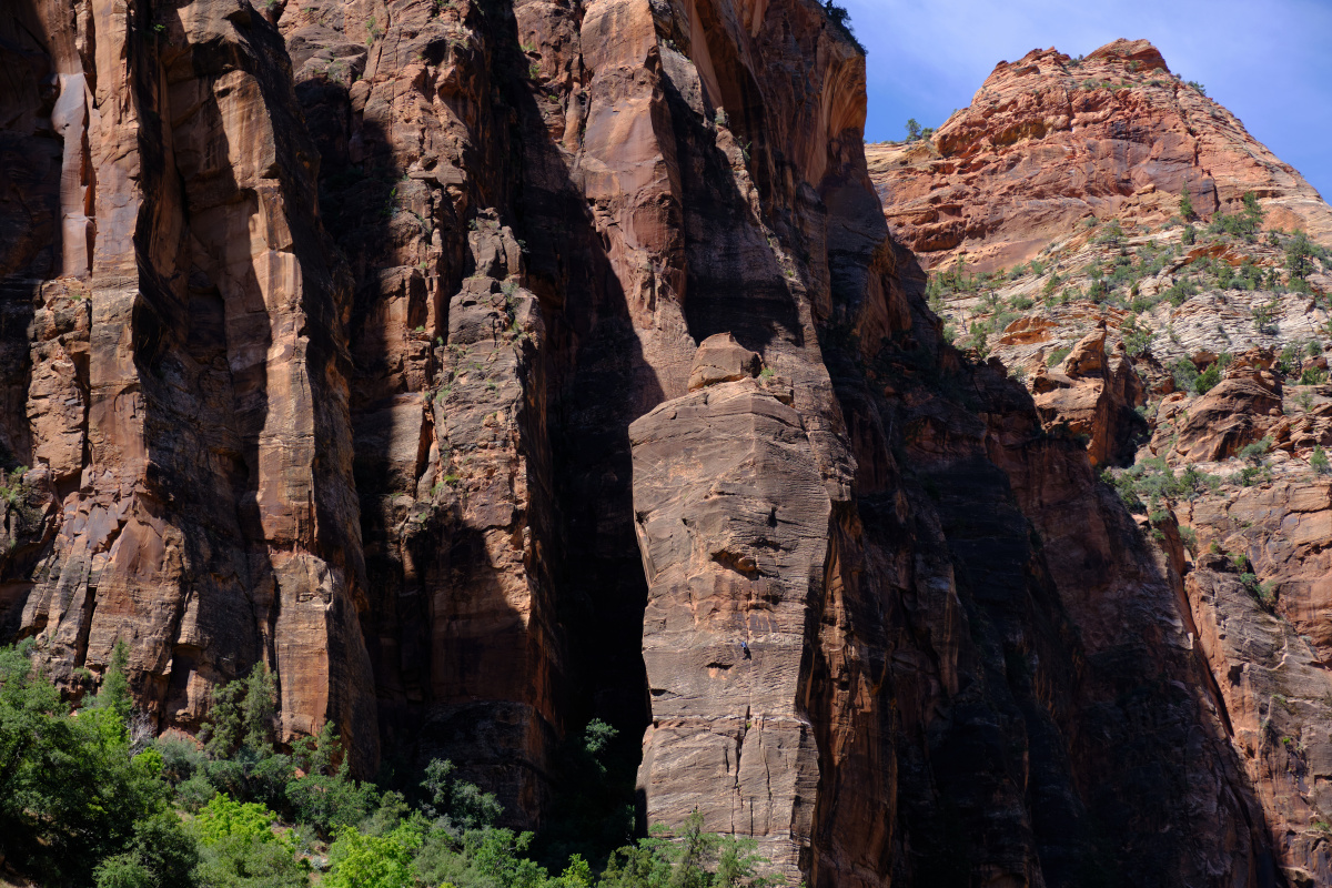 在zion国家公园岩壁上爬传统的攀爬者.