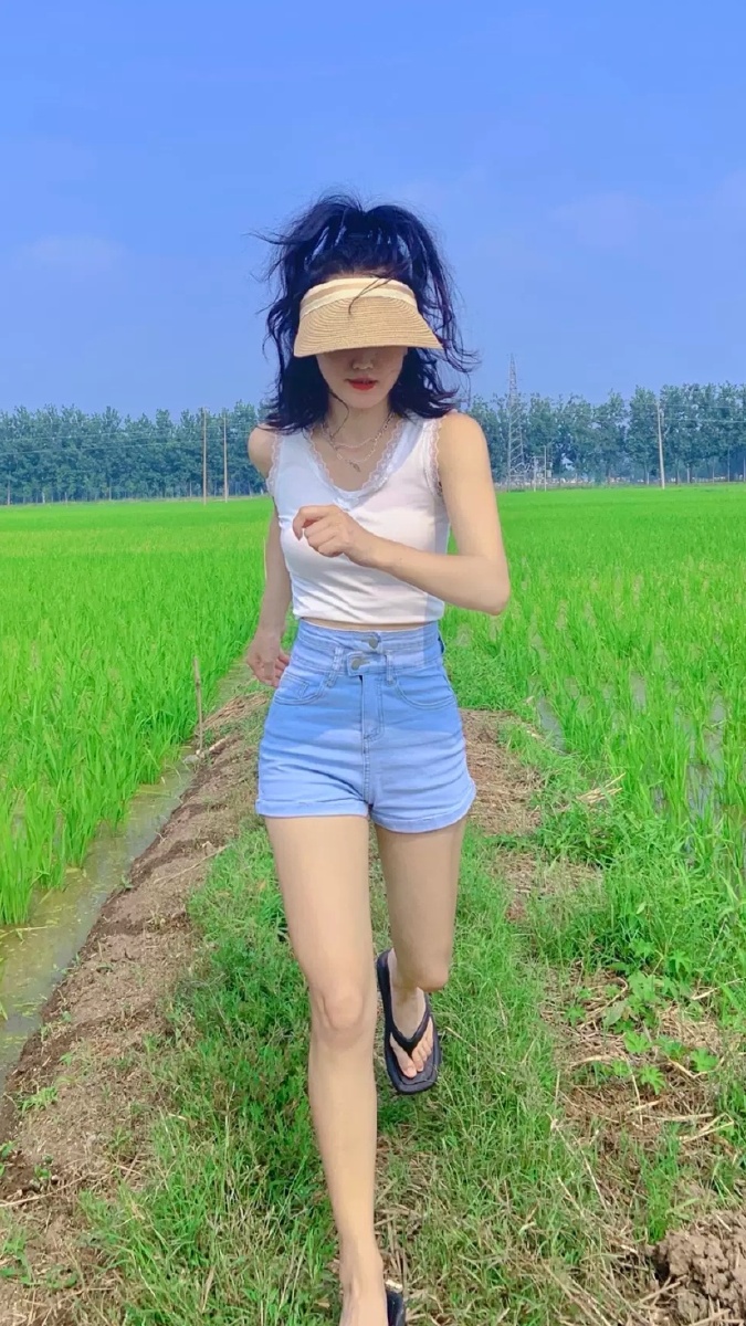 小背心短裤加绿草地更能衬托美女的清纯靓丽