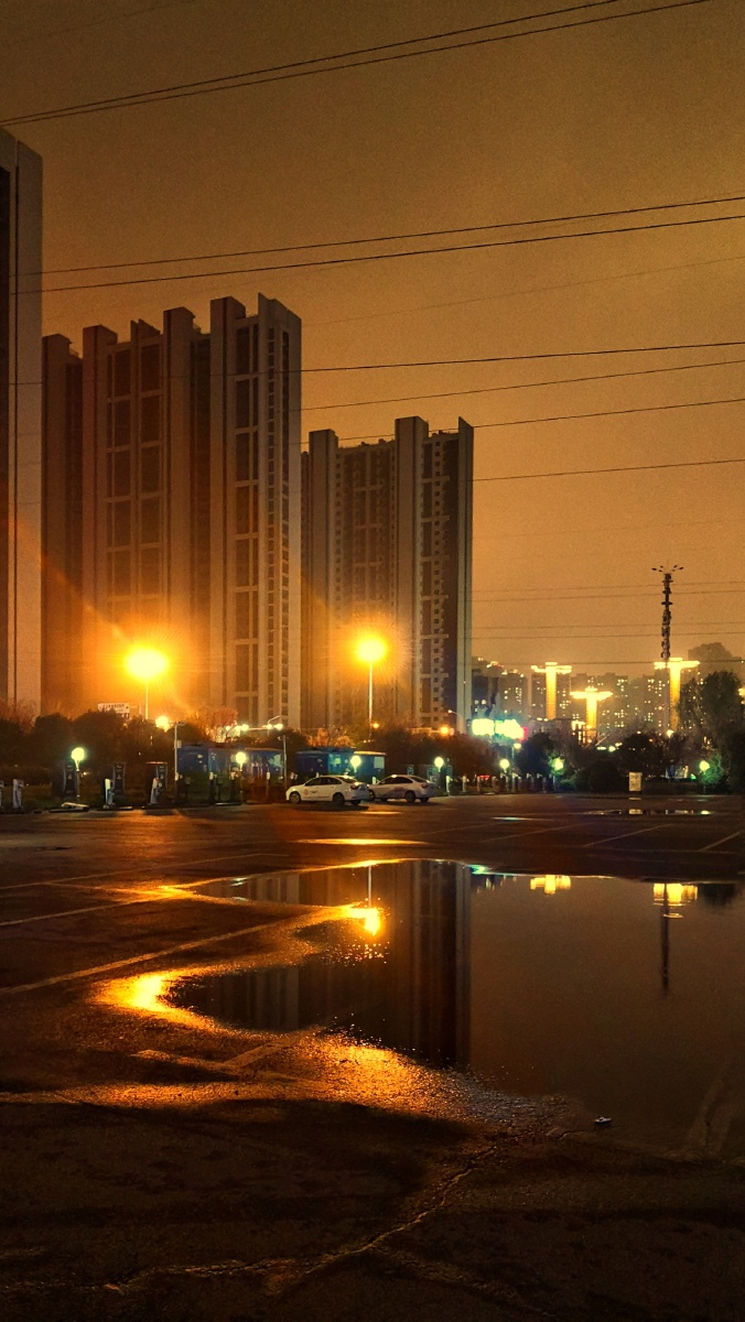 细雨朦胧中的城市之夜有几分冷清行走在路上的的夜归人也许只有那暖桔