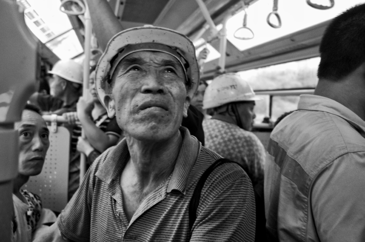 在横琴开往西区的公交车上刚下班的建筑工人披着满身的疲惫45角斜视着