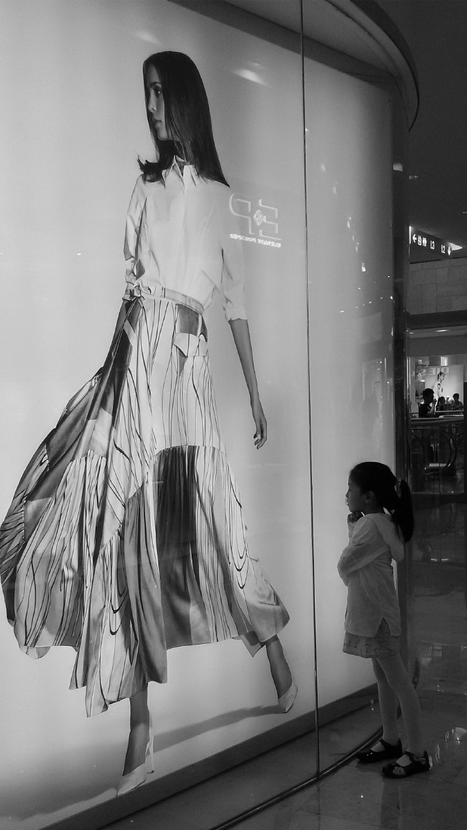 望着橱窗的小女孩