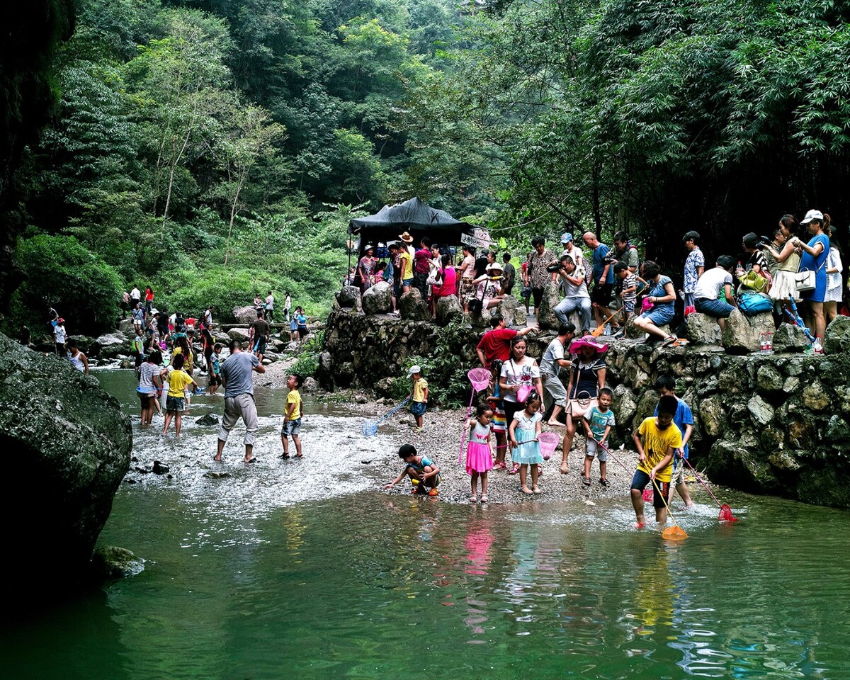 游山玩水_07-2014年，宜昌三峡大瀑布景区里在小河里玩水捕鱼的小孩。