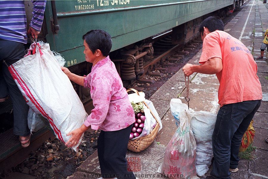 【人民綠皮】
2012年8月，湖南，白石渡車站。新鮮的蔬菜，被農民帶到郴州售賣，第二天他們再乘坐這個列車回到白石渡。這班從郴州開往白石渡又返回郴州的列車，每日開行一次，沿途各站均停，旅客也不必購買車票。站台上的大叔笑言：“這就是人民鐵路為人民。”