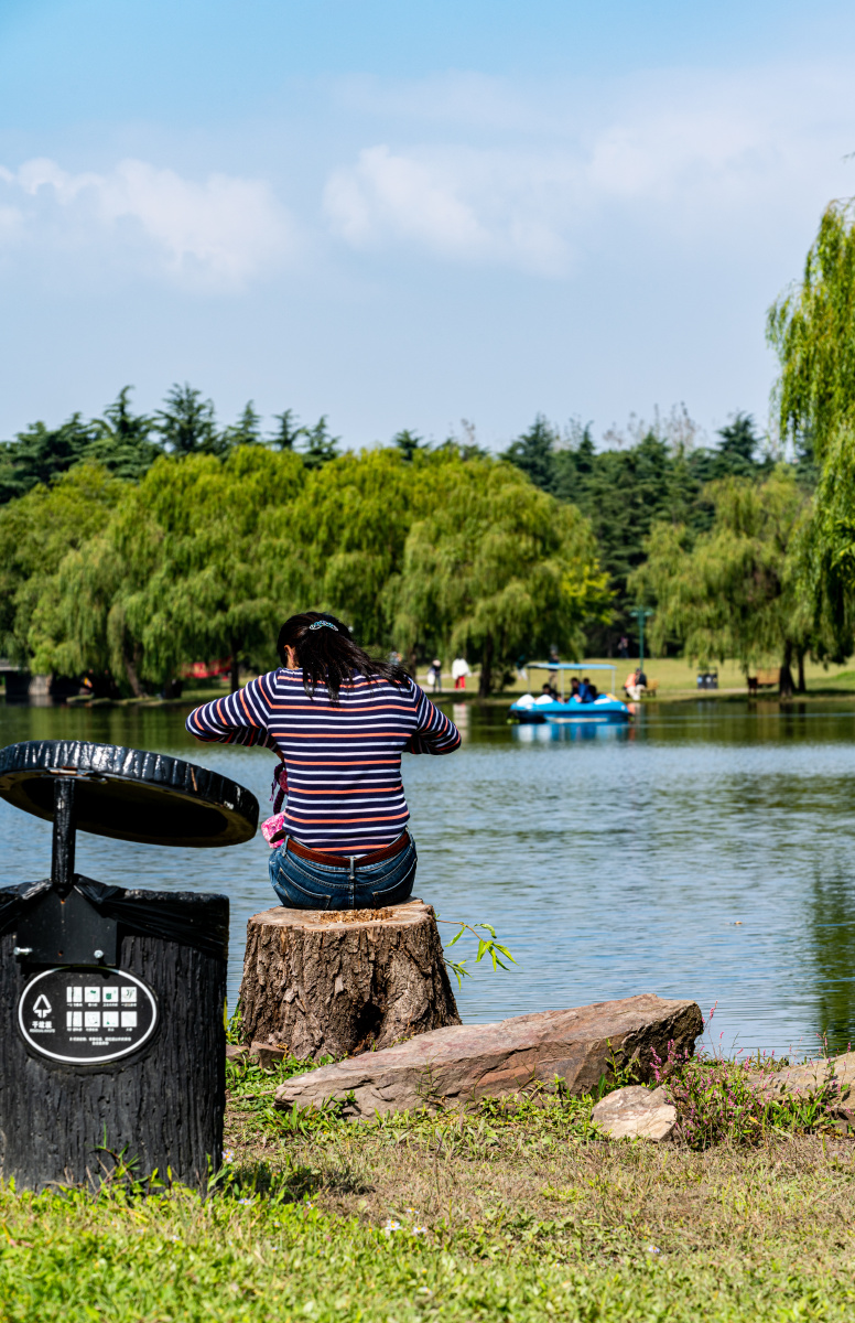 上海共青森林公园湖畔观秋色的游客