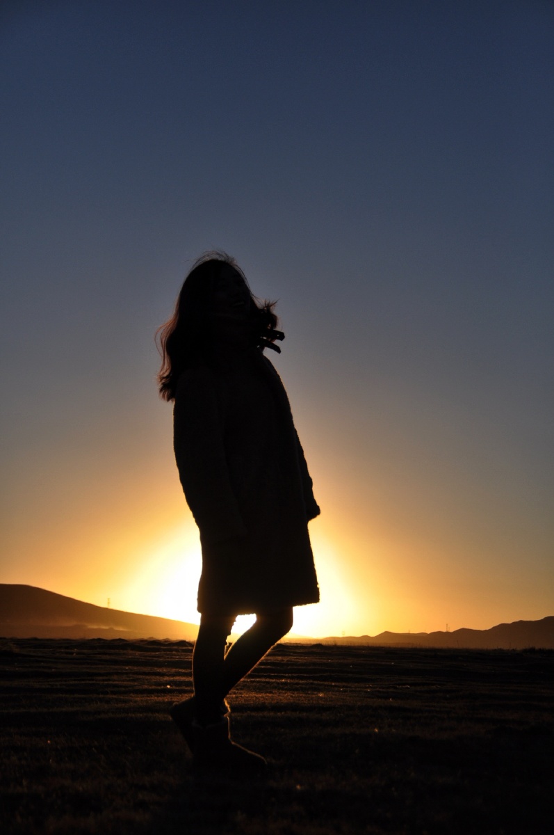 太阳向西边的地平线转瞬即落又朝黎明破晓的方向东升人像面向朝阳冉冉