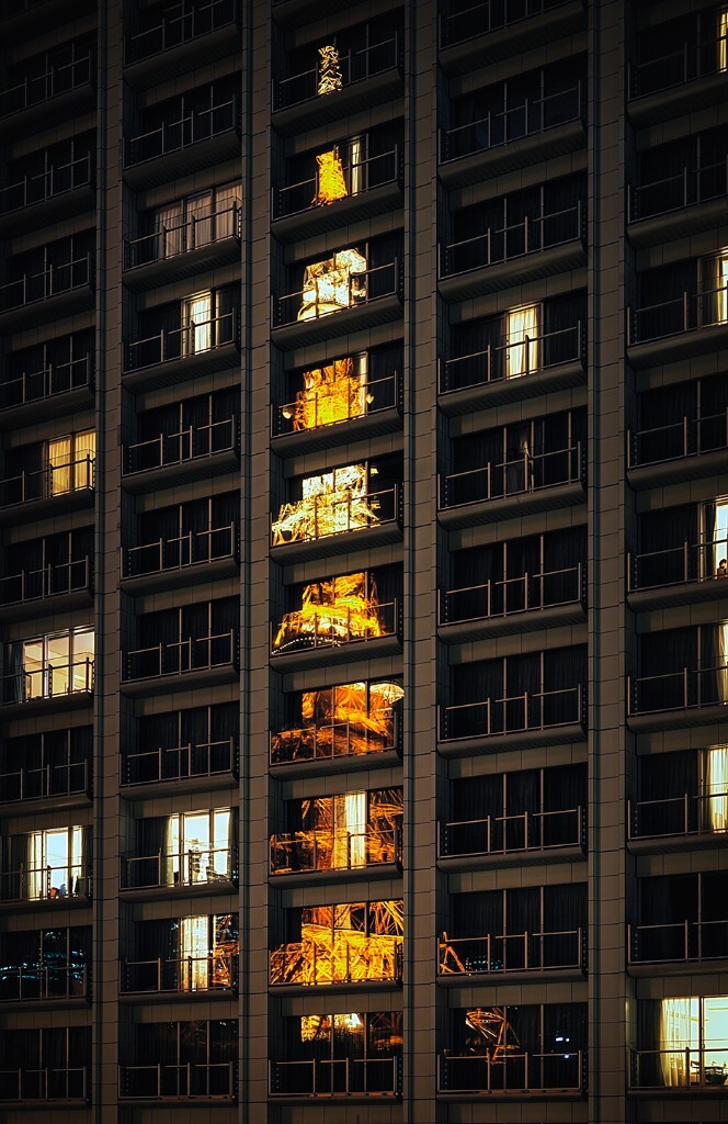 一整幢大楼的落地玻璃窗中反射出灯火辉煌的东京塔。