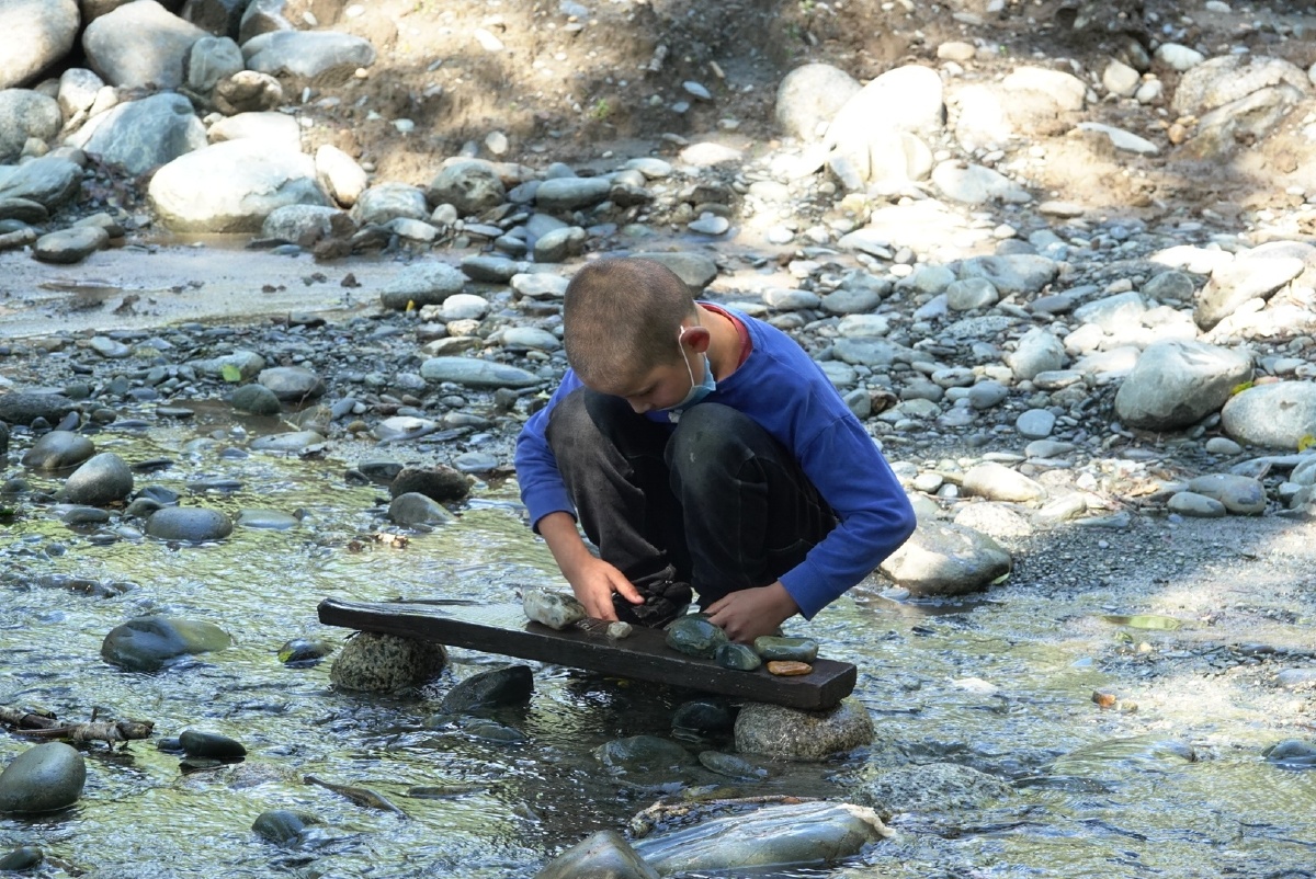 城市孩子们玩乐高乡村的孩子玩石子也津津有味