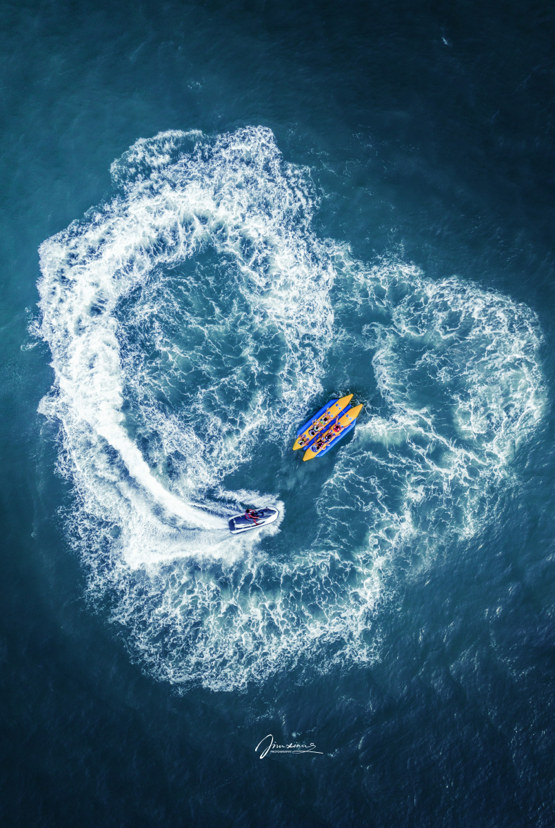 如摩托艇溅起的浪花如爱心般包裹着一船人.