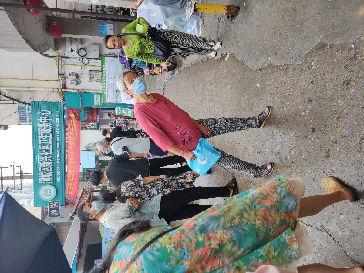 某小区正排队等候打新冠疫苗的人们