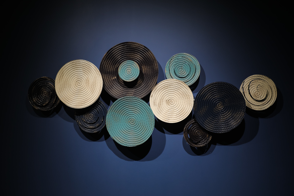 蓝色墙面上的陶瓷圆形螺旋状白色黑色蓝色立体盘子艺术品