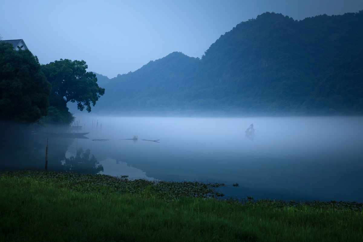 之江的清晨,白雾缭绕,小舟若隐若现,宁静而悠远