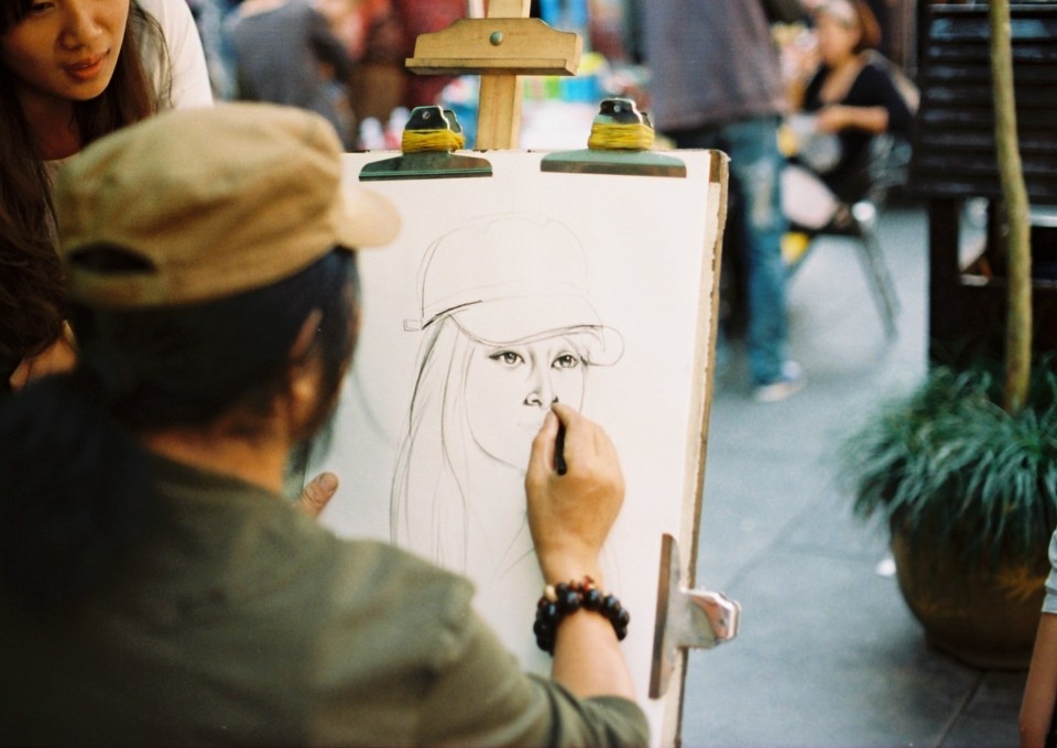 肖像 br /> 杭州河坊街,一位街头肖像画家在一位女士画肖像.