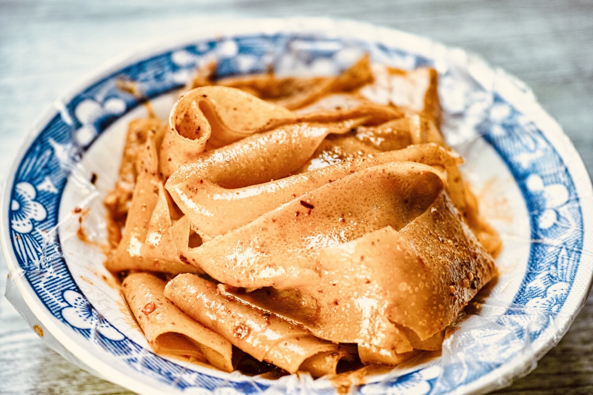 陕西宝鸡特色小吃烙面皮顾名思义就是在类似煎饼果子那种饼档上烙出来