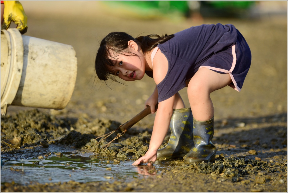 生活在海边的小女孩在家门口看到妈妈在滩涂上捡海螺,欢快地飞奔过来