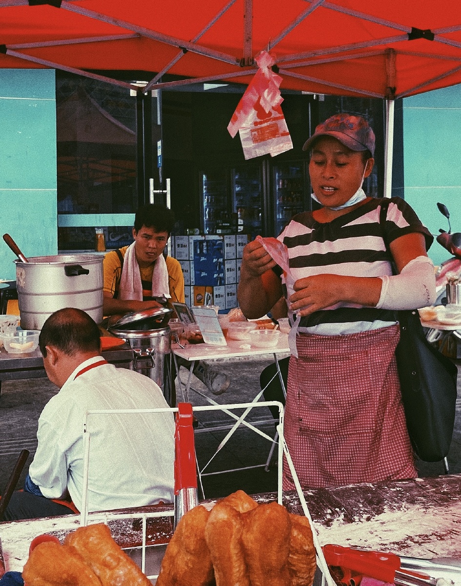 早餐摊抓拍路边的早餐摊大红的太阳伞下售卖着豆浆油条肠粉顾客不多多